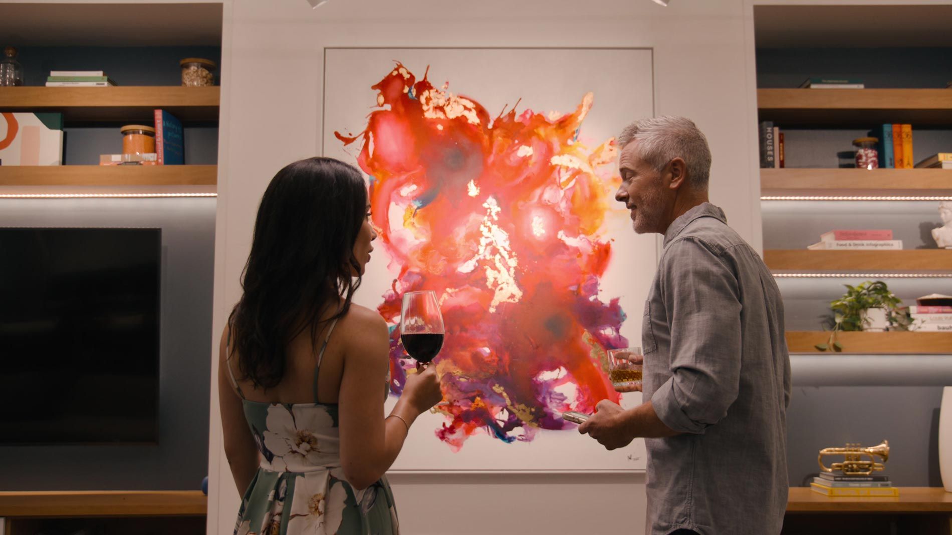 Two people admiring a vibrant abstract painting