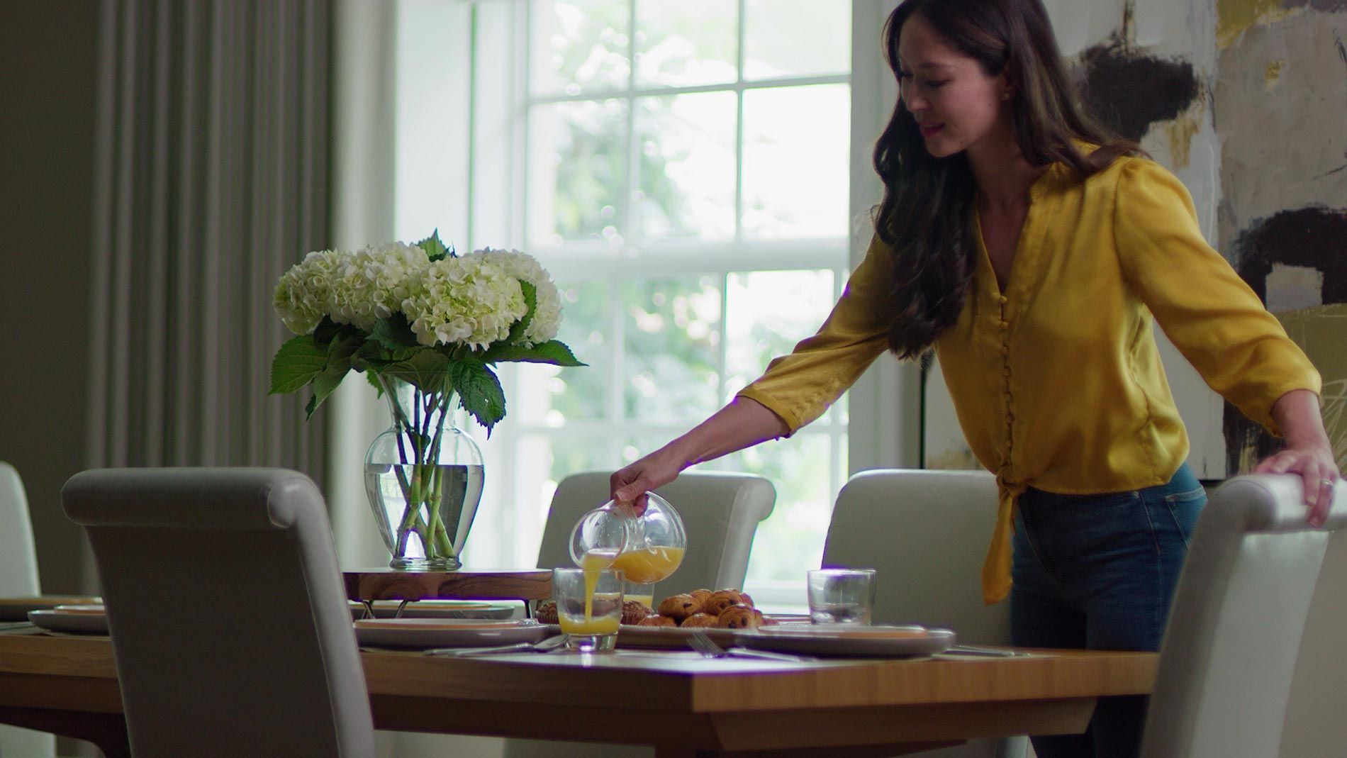 Woman pouring juice at a dining table