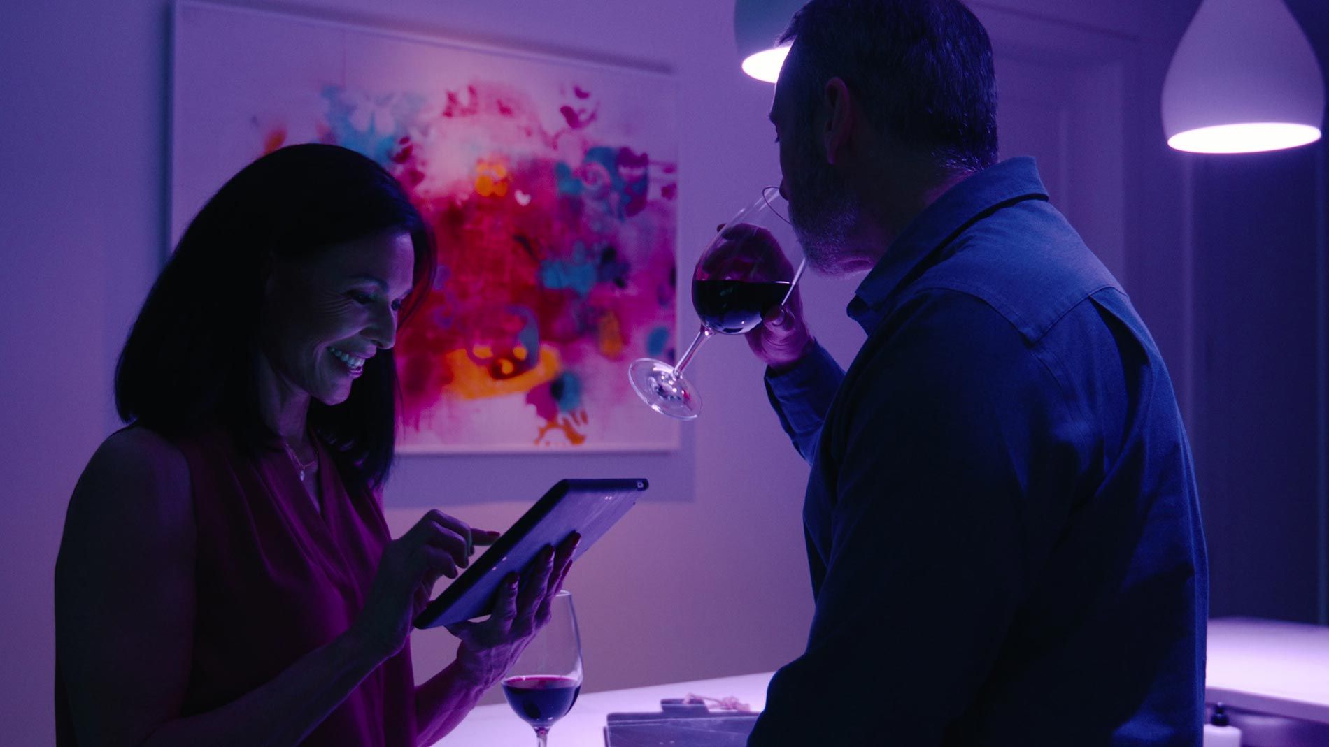 Couple enjoying wine with ambient purple lighting