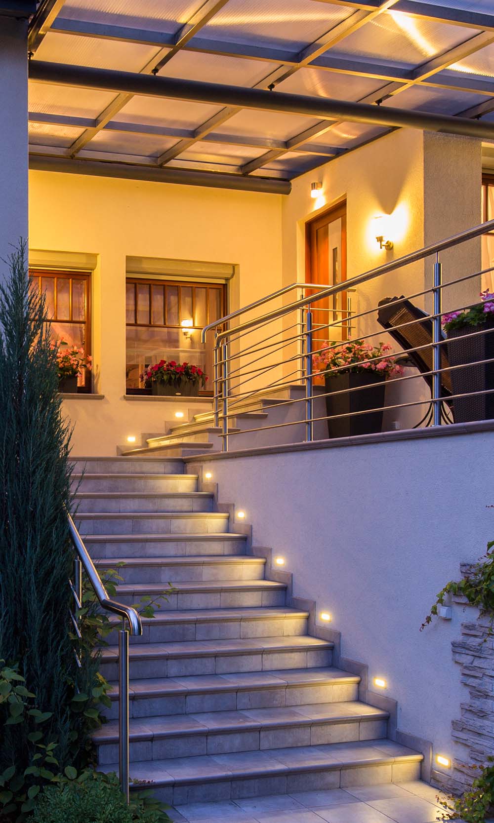 Front area of a house with lighted stairs and patio